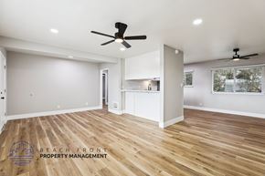 Lomita apartment for rent - A spacious room with wooden floors and two ceiling fans.