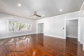 Long Beach apartment for rent - A spacious room with wooden floors and a ceiling fan.