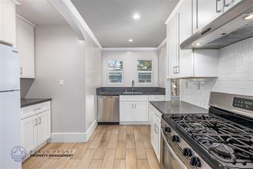 Long Beach apartment for rent - A kitchen with white cabinets and a black stove top.
