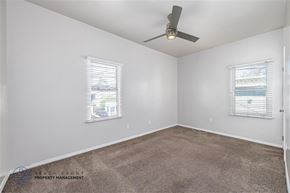 Long Beach apartment for rent - A room with a ceiling fan and two windows.