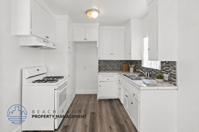 Inglewood apartment for rent - A kitchen with white cabinets and a wooden floor.
