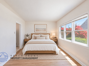 Long Beach apartment for rent - A bedroom with a large bed and a window overlooking a garden.