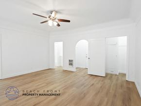 Long Beach apartment for rent - A spacious room with a ceiling fan and wooden flooring.