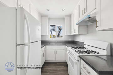 Hawthorne apartment for rent - A kitchen with white cabinets and a black countertop.