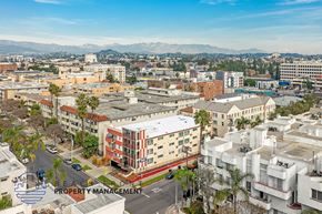 Los Angeles apartment for rent - A cityscape with buildings and a mountain range in the background.