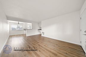 Whittier apartment for rent - A spacious room with wooden flooring and white walls, with a window and a door visible.