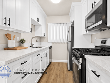 Playa Del Rey apartment for rent - A kitchen with white cabinets and a black stove top.
