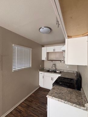 Anaheim apartment for rent - A kitchen with a sink, stove, and cabinets.