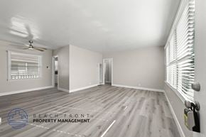 Santa Ana apartment for rent - A spacious room with wooden flooring and a ceiling fan.