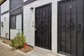 Westminster apartment for rent - A black gate with a decorative design is on the right side of a white building.