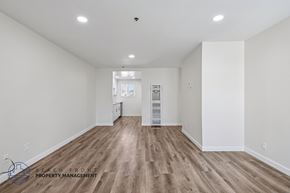 Hawthorne apartment for rent - A spacious room with wooden flooring and white walls.