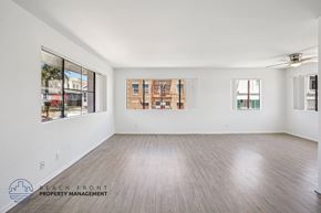 San Pedro apartment for rent - A spacious room with wooden flooring and large windows overlooking a cityscape.