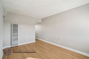 Hawthorne apartment for rent - A spacious room with a wooden floor and a window with blinds.