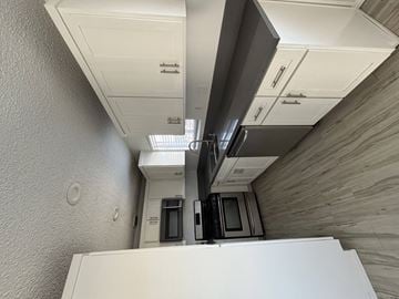 Long Beach apartment for rent - A kitchen with white cabinets and a white refrigerator.