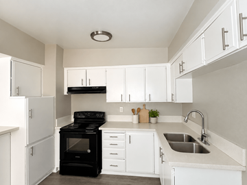 Long Beach apartment for rent - A black stove in a white kitchen with a sink.