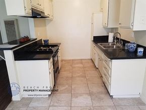 Inglewood apartment for rent - a kitchen with white cabinets and black counter tops