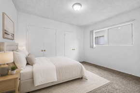 Huntington Park apartment for rent - A bedroom with a bed, nightstand, and two doors.