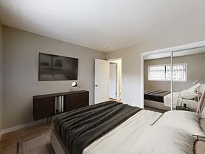 Lawndale apartment for rent - A bedroom with a large bed and a television on the wall.