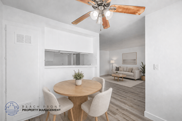 Hawthorne apartment for rent - A dining room with a round table and chairs, a ceiling fan, and a living room with a couch in the background.