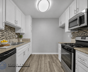 Long Beach apartment for rent - A kitchen with white cabinets and a stone backsplash.