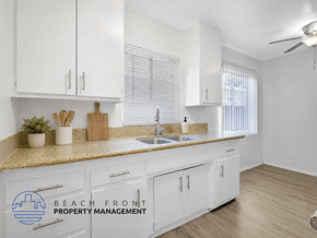 Inglewood apartment for rent - A kitchen with white cabinets and a countertop with a sink and a plant on it.