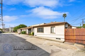 Long Beach apartment for rent - a street view of a white building with a wooden fence