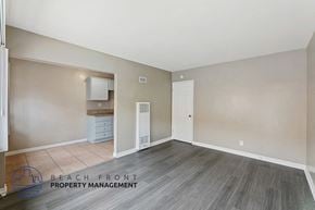 Long Beach apartment for rent - a living room with white walls and a wooden floor and a door to a closet