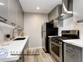 Los Angeles apartment for rent - A modern kitchen with stainless steel appliances and a marble countertop.