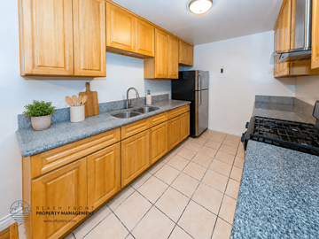Los Angeles apartment for rent - A kitchen with wooden cabinets and a black fridge.