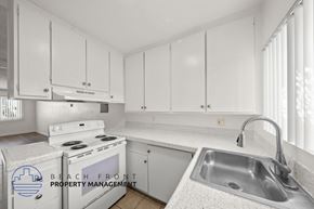 Gardena apartment for rent - A kitchen with white cabinets and a stove top oven.