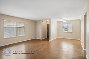 Lakewood apartment for rent - A spacious room with wooden flooring and a logo for Beach Front Property Management.