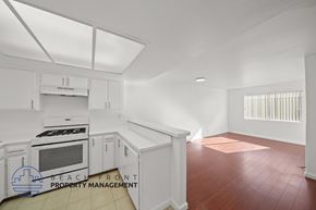 Santa Monica apartment for rent - A kitchen with white cabinets and a stove top oven.