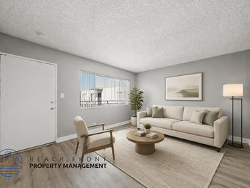 Torrance apartment for rent - A living room with a white sofa, a wooden chair, a coffee table, and a painting on the wall.