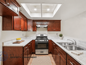 Santa Ana apartment for rent - A kitchen with wooden cabinets and a stove top oven.