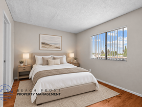 Long Beach apartment for rent - A bedroom with a large bed and a view of the beach through the window.