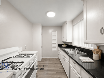 Long Beach apartment for rent - A kitchen with a white stove top and a black counter top.