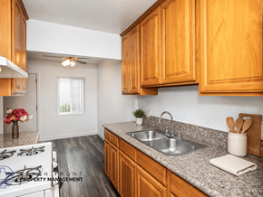 Downey apartment for rent - A kitchen with wooden cabinets and a granite countertop.