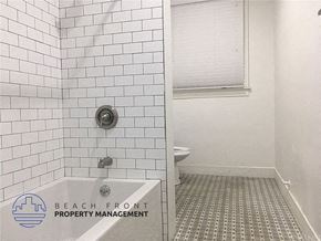 Los Angeles apartment for rent - a white tiled bathroom with a shower and a toilet