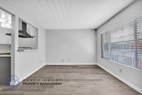 Long Beach apartment for rent - the spacious living room with a large window and wood flooring