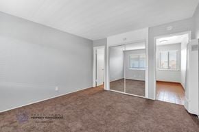 Carson apartment for rent - A spacious room with a carpeted floor and a sliding glass door leading to a balcony.