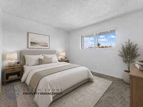 Huntington Beach apartment for rent - A well-lit bedroom with a large bed and a view of the beach through the window.