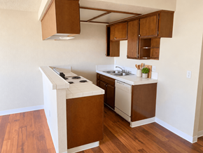 San Pedro apartment for rent - A kitchen with brown cabinets and a white stove top oven.