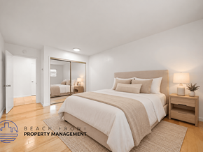 Santa Monica apartment for rent - A bedroom with a large bed, a nightstand, and a mirror on the wall.