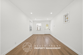 Santa Monica apartment for rent - a living room with white walls and wood floors and a white door