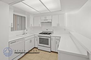 Santa Monica apartment for rent - A white kitchen with a stove, sink, and cabinets.