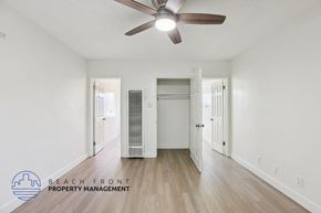 Hawthorne apartment for rent - A spacious room with a ceiling fan and a wooden floor.