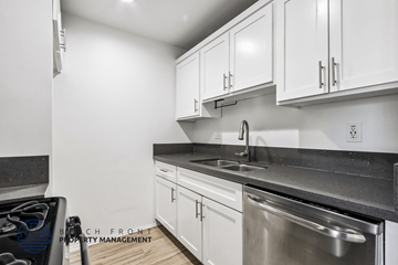 Long Beach apartment for rent - A modern kitchen with white cabinets and stainless steel appliances.