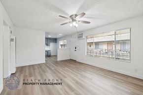 La Habra apartment for rent - A spacious room with a ceiling fan and wooden flooring.