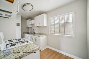 Hawthorne apartment for rent - A kitchen with a granite countertop and white cabinets.