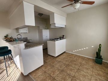 San Pedro apartment for rent - A kitchen with white cabinets and a counter top.